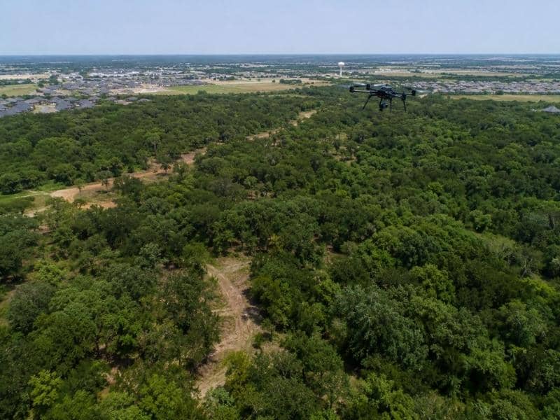 Drone Survey capturing aerial data over a wooded development tract in McKinney Texas